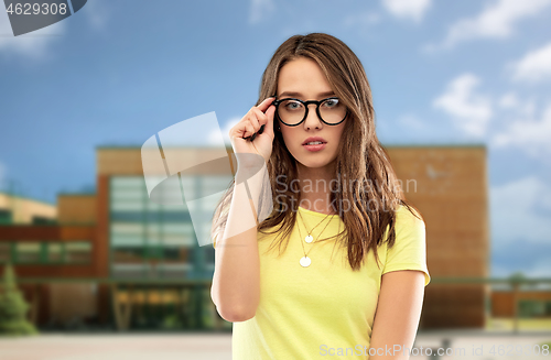 Image of young woman or teenage girl in glasses over school