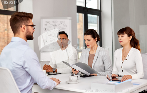 Image of recruiters having job interview with male employee