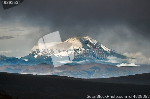 Image of Chimborazo peak in the distance, dark clouds