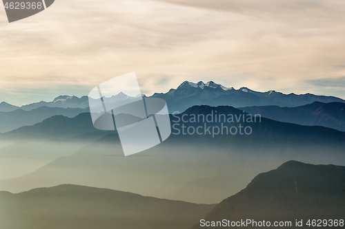 Image of Mountain peaks above moving clouds and mist