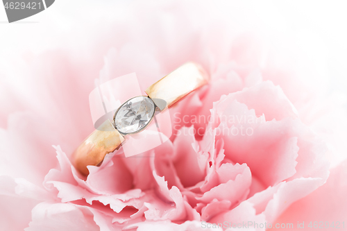 Image of Wedding or engagement ring in a flower. Soft focus.