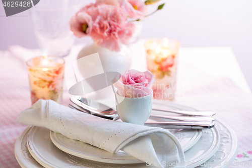 Image of Place setting with beautiful bouquet in pink and white on the kitchen table