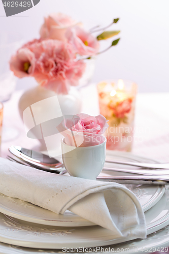 Image of Place setting with beautiful bouquet in pink and white on the kitchen table