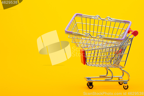 Image of In an empty grocery cart lies an empty grocery basket