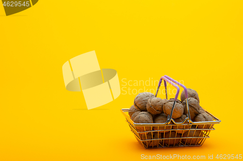 Image of Walnuts are in the grocery basket, bright orange background