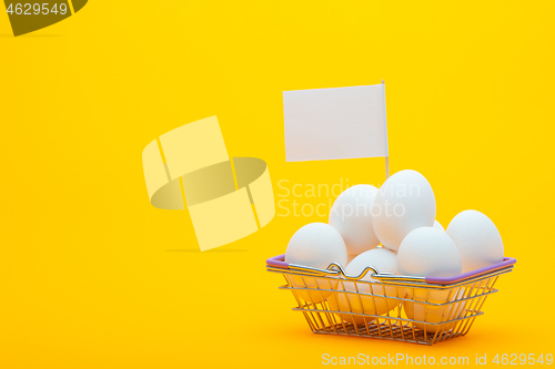 Image of Metal grocery basket with eggs, a price tag is stuck