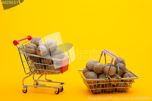 Image of Walnuts are in the grocery basket and trolley, bright orange background