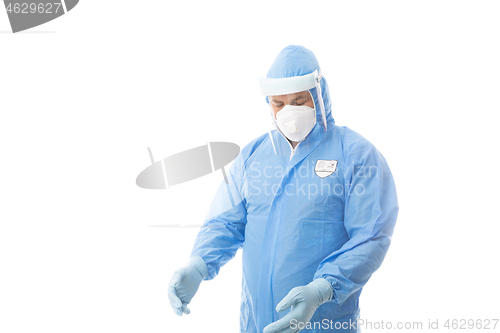 Image of Worker wearing a hasmat coverall, maskgloves  and face shield