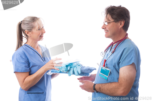 Image of Hospital healthcare worker hands a PPE kit to another nurse or d