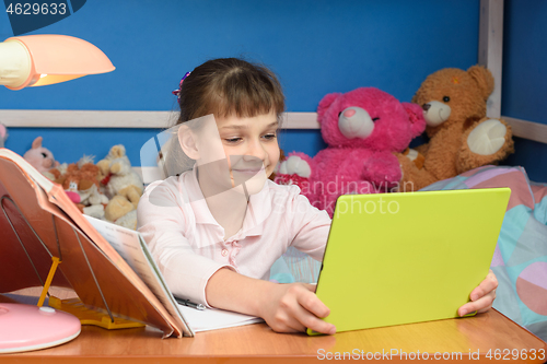 Image of Cheerful girl in self-isolation mode studying at home