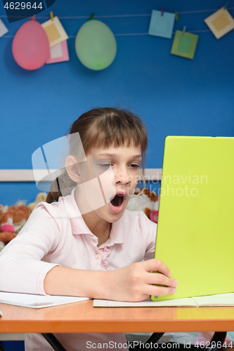 Image of Girl yawns and watches video tutorials on a tablet