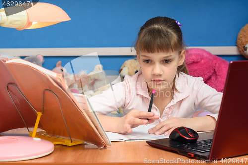 Image of The girl thought about the task while doing homework