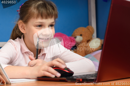 Image of Happy girl at home performs online homework