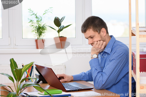 Image of Office specialist working in a laptop at his workplace