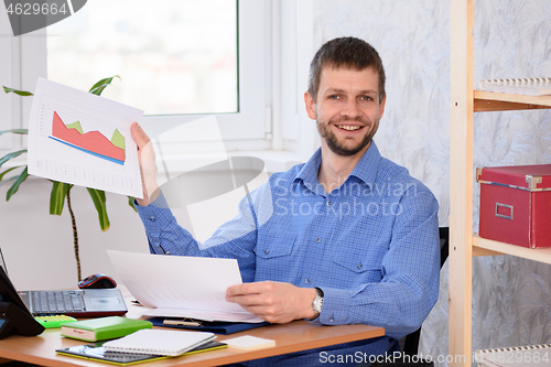 Image of Office employee joyfully showing a document with charts