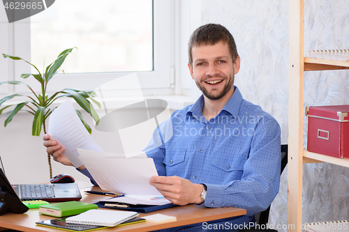 Image of Successful businessman joyfully looks at the paper and looked into the frame