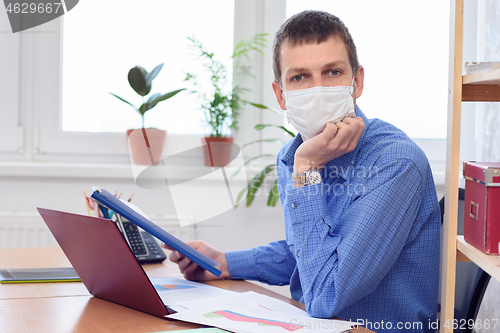 Image of Office specialist in a medical mask at work