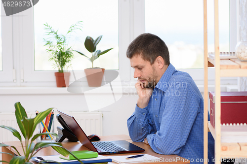 Image of A typical weekday office specialist working on a computer while sitting at a desk