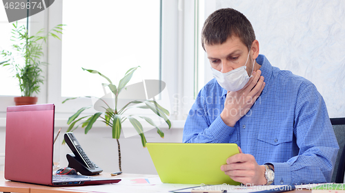 Image of Ill employee in the office holds his throat