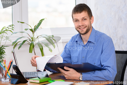 Image of Successful male businessman at workplace in office