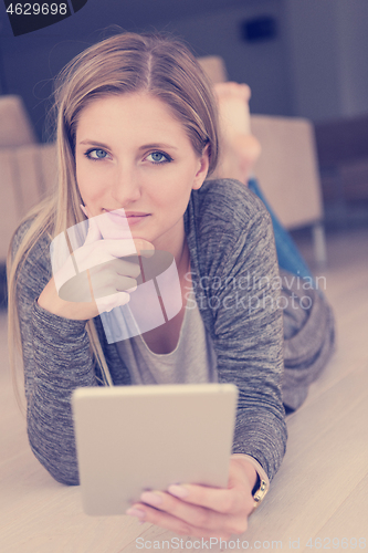 Image of young women used tablet computer on the floor