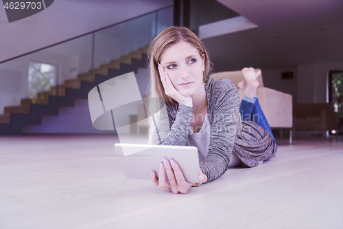 Image of young women used tablet computer on the floor