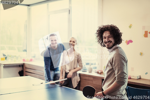 Image of startup business team playing ping pong tennis