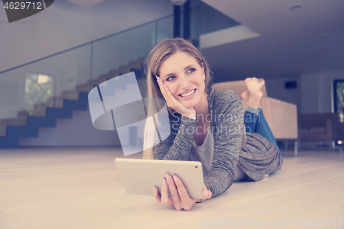 Image of young women used tablet computer on the floor