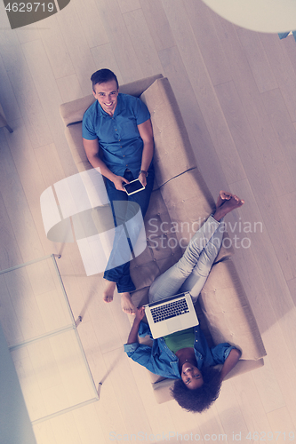 Image of young multiethnic couple relaxes in the living room top view