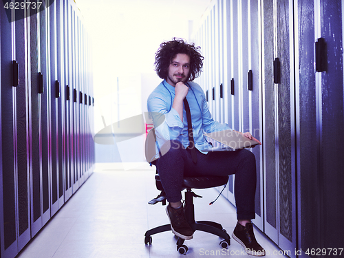 Image of engineer working on a laptop in server room