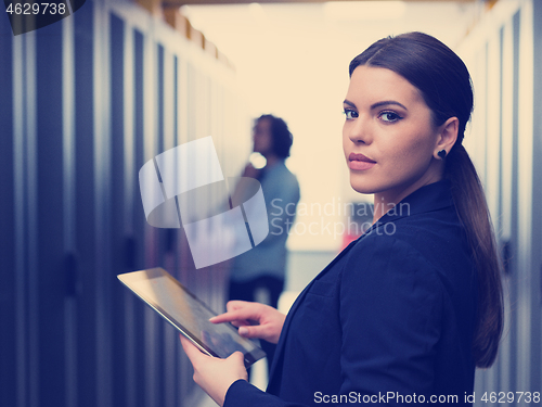 Image of Female engineer working on a tablet computer in server room