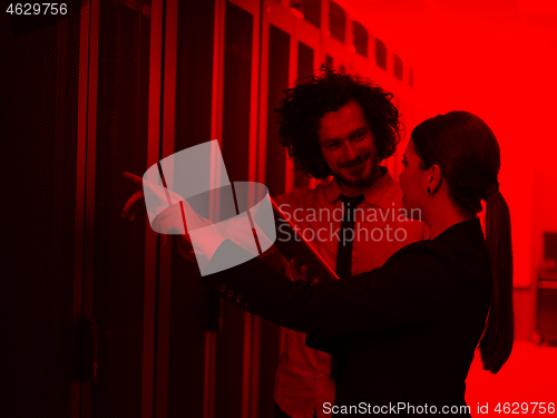 Image of engineer showing working data center server room to female chief