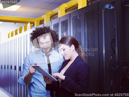 Image of engineer showing working data center server room to female chief