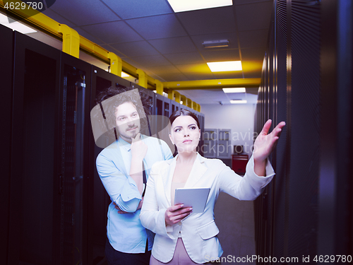 Image of engineer showing working data center server room to female chief