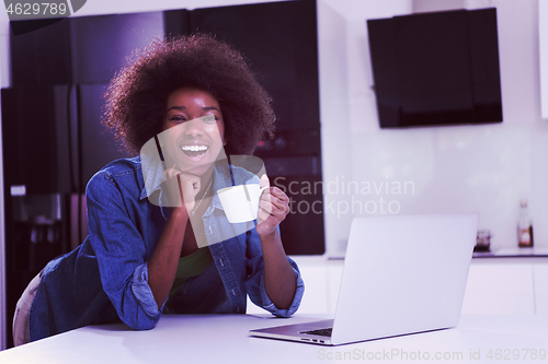 Image of smiling black woman in modern kitchen