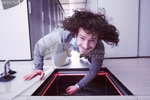 Image of engineer connecting cables in server room