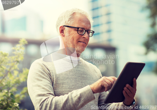 Image of senior man with tablet pc on city street