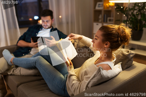 Image of couple with tablet computer and book at home