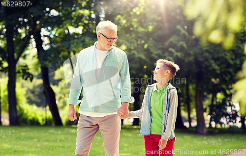 Image of grandfather and grandson walking at summer park