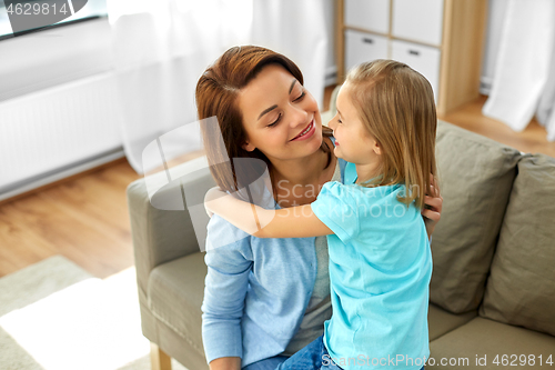 Image of little daughter hugging her mother at home