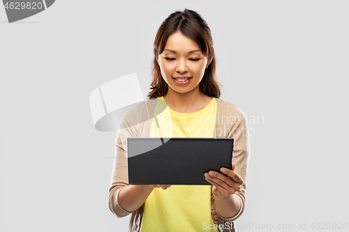 Image of happy asian woman using tablet computer