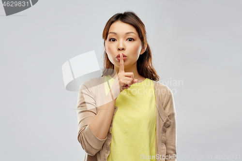 Image of asian woman with finger on lips