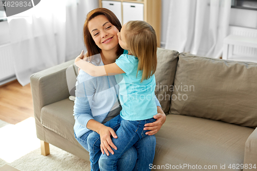 Image of daughter hugging and kissing her mother at home