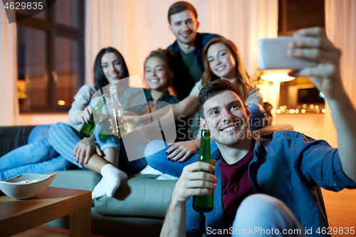 Image of happy friends taking selfie by smartphone at home