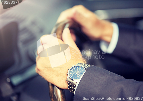 Image of senior businessman hands driving car