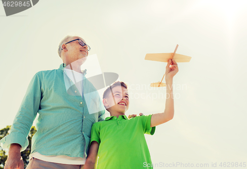 Image of senior man and boy with toy airplane over sky