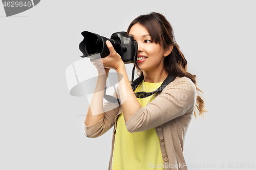 Image of asian female photographer with digital camera