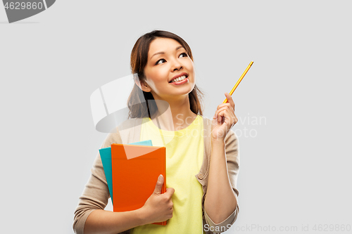 Image of asian student woman with books and pencil