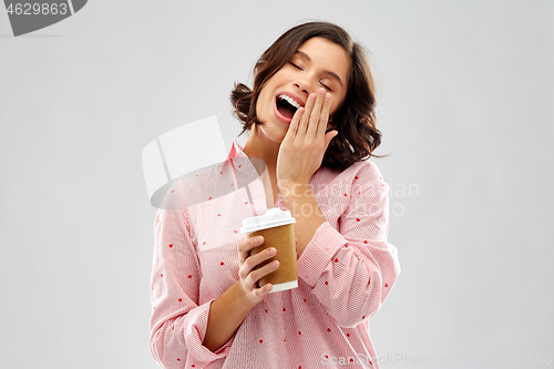 Image of happy young woman in pajama with cup of coffee