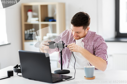 Image of male audio blogger connecting cable to microphone